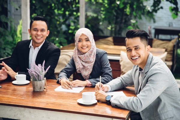 3 people sitting around a cafe table